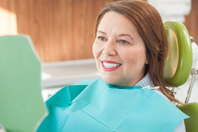 Red hair lady looking into mirror with a nice smile